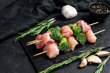 Obraz na płótnie Canvas fresh raw chicken pieces on skewers. Black background. Top view