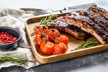Delicious barbecued ribs seasoned with a spicy basting sauce and served with baked tomatoes. Gray...