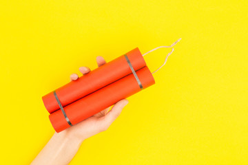 cropped view of man holding dynamite isolated on yellow