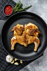 Grilled chicken with pepper and rosemary. Gray background. Top view