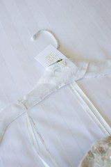 Fototapeta na wymiar white wedding dress hanger straps on white bed 