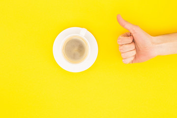 cropped view of man showing thumb up near coffee isolated on yellow