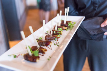 waiter serving tray with bbq Hors d'oeuvre