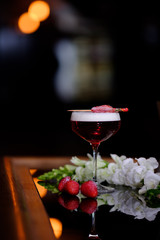 glass of red wine and rose on black background