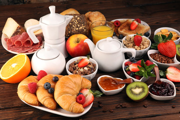 Breakfast served with coffee, orange juice, croissants, cereals and fruits. Balanced diet. Continental breakfast with granola and fruits