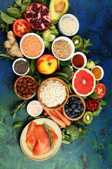 Healthy food clean eating selection: fish, fruit, vegetable, cereal, leaf vegetable on rustic background