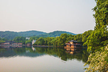 Fototapeta premium West Lake landscape with reflections in water at sunset, Hangzhou, China