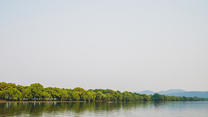 West Lake landscape with reflections in water at sunset, Hangzhou, China