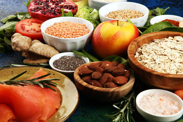 Healthy food clean eating selection: fish, fruit, vegetable, cereal, leaf vegetable on rustic background