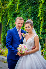  Bride and Groom at wedding Day walking Outdoors on spring nature. Bridal couple, Happy Newlywed woman and man embracing in green park. Loving wedding couple outdoor.