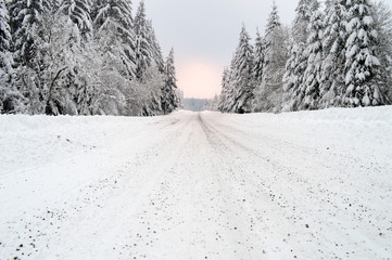 Beautiful winter landscape with a dangerous and slippery snow-covered mountain road