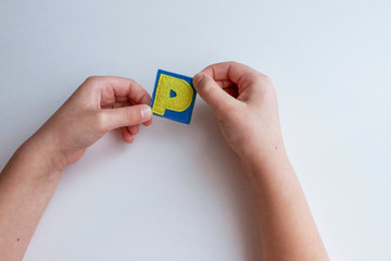 Alphabet. Letter  P. Hands of the child hold letters. Learn ABC alphabet with baby.