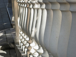 stone balusters, leaving in perspective. White railings, elements of stone stairs in the city.