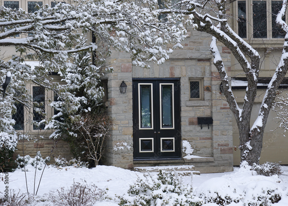 Wall mural front of stone fronted snow covered house