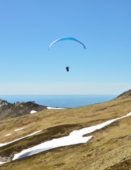 Paraglider flies on top of a volcanic mountain. This is extreme sport