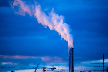 Atmospheric Air Pollution From Industrial Smoke billowing from Smoking pipes and cranes beside smoking pipes, ecology problems paris france