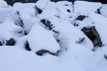 Snow covered on the rocks beside the lake.