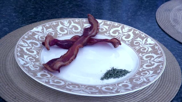 Two slices of Bacon on a plate with Cannabis Breakfast