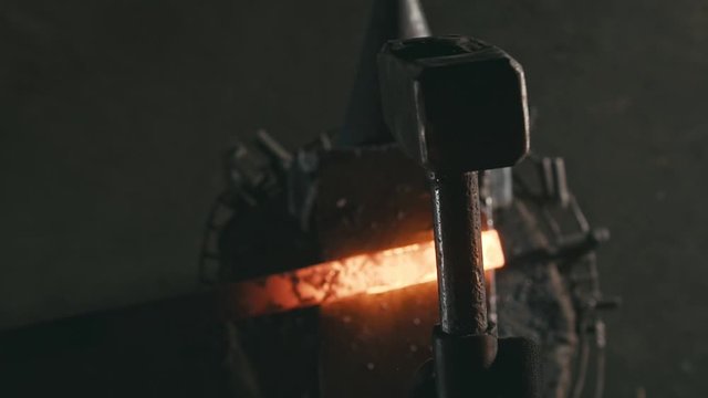 Forge workshop. Smithy manual production. Hands of smith with hammer hit on glowing hot metal, on the anvil, the forging process. Blacksmith makes iron products for manufacture of fireplace, stove.