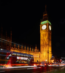 Big Ben und Parlament (Westminster Palace) mit rotem Doppeldecker-Bus bei Nacht. London, UK.