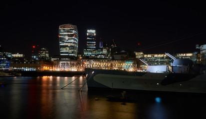 Fototapeta na wymiar Kriegsschiff HMS Belfast mit Hochhaus Walkie Talkie (20 Fenchurch St) und Gherkin (30 St Mary Axe) im Hintergrund. London, UK.