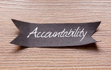 Accountability word written on Black papper with wooden background