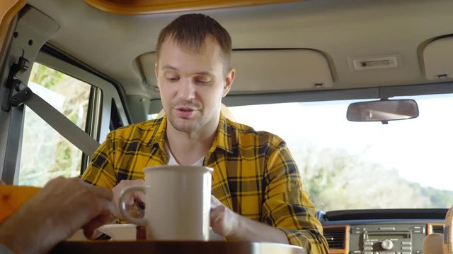 maman eating meat at a table in a motorhome. car travel concept