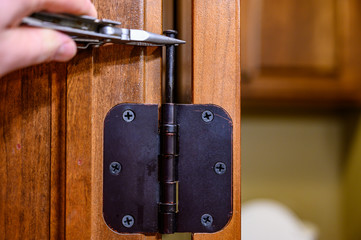 Oiled bronze door hinge with pin being removed - obrazy, fototapety, plakaty