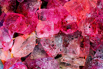 Red and pink colored ice cubes melting 