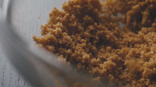 Mixing honey and crakers crumbs in a bowl. close up shot. cooking in the kitchen
