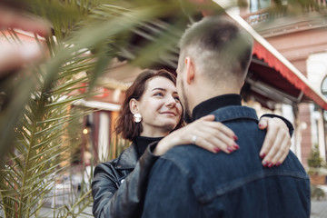 Naklejka premium Young couple in love hugs and spend time together in the city against the backdrop of urban architecture.