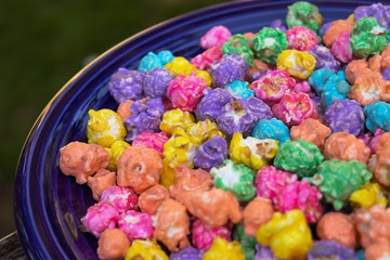 brightly colored rainbow popcorn on a blue plate