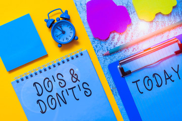Writing note showing Do S And Don T S. Business concept for Confusion in one s is mind about something Notepad clipboard sheet marker car sticks alarm clock wooden background