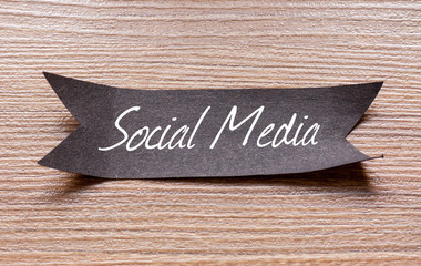Social Media words written on Black papper with wooden background