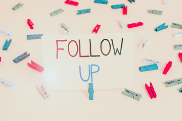 Text sign showing Follow Up. Business photo text a continuation of something that has already been started Colored clothespin papers empty reminder yellow floor background office