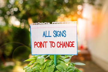 Word writing text All Signs Point To Change. Business photo showcasing Necessity of doing things differently new vision Plain empty paper attached to a stick and placed in the green leafy plants