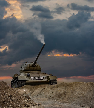 A war scene of a tank climbing up the hill with a smoking turret under a dramatic sunset
