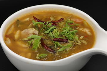 Spicy Thai herb soup with boiled chicken and mushroom