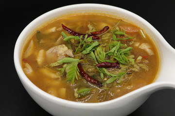 Spicy Thai herb soup with boiled chicken and mushroom