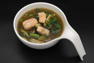 Thai herb soup with salmon on top