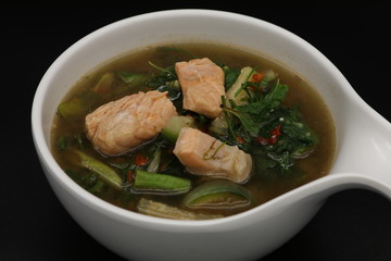 Thai herb soup with salmon on top