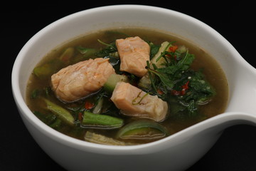Thai herb soup with salmon on top