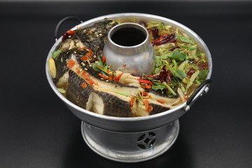 Thai soup with boiled fish with herbs and chili