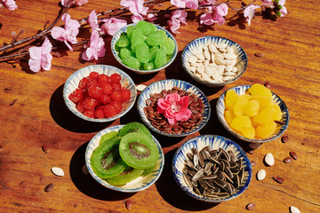 Seeds, dried berries and fruits served in small ceramic bowls for Lunar New Year