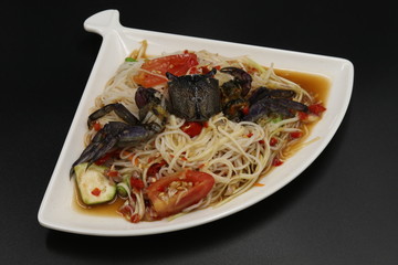 Thai spicy salad with black crab in white plate