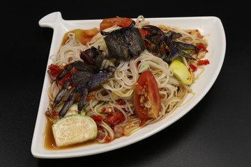Thai spicy salad with black crab in white plate
