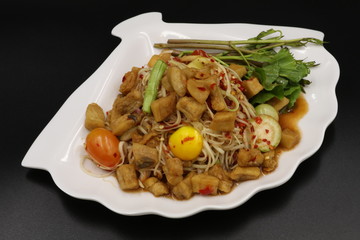 Somtum (Thai spicy salad) with pork rind and vegetable in white plate
