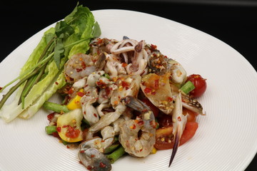 Somtum (Thai spicy salad) with raw prawn and raw crab in white plate