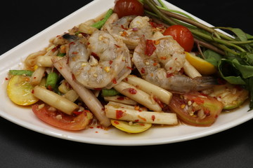 Thai spicy salad with raw prawn in white dish