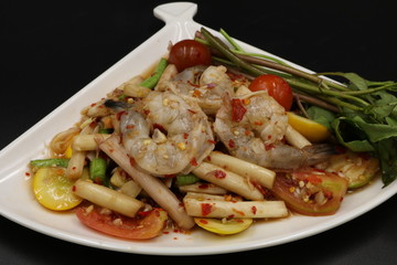 Thai spicy salad with raw prawn in white dish
